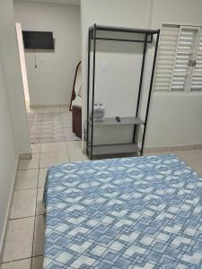 a bedroom with a bed and a tv on a wall at Apartamento loft in Poços de Caldas