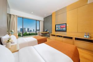 a hotel room with two beds and a flat screen tv at Sheraton Guangzhou International Service Apartment (Pazhou Convention and Exhibition Center Branch) in Guangzhou +9 photos