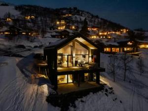 una pequeña casa en la nieve por la noche en Luxury Cabin With Panoramic Views In Stranda, en Stranda