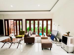 a living room with a couch and a tv at KAUH House Canggu in Tumbak Bayuh
