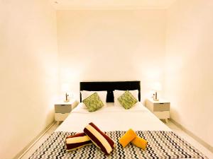 a bedroom with a large white bed with two pillows at KAUH House Canggu in Tumbak Bayuh +4 photos