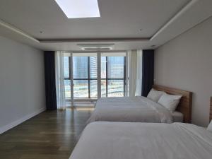 Ένα ή περισσότερα κρεβάτια σε δωμάτιο στο Haeundae Ocean View Full option Residence 67 +35 φωτογραφίες
