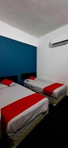 two beds in a room with blue and white at Captain Hotel Cafe & Bistro in Sitiawan