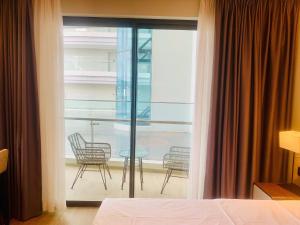 a bedroom with a balcony with chairs and a table at The Luxury Studio Near the Seaside in Ha Long +32 photos
