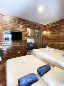 パングラオにあるBalai Alona - Deluxe Roomのベッド2台と薄型テレビ付きの部屋