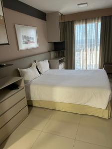 a bedroom with a large bed and a window at Flat em Cullinan, 5 estrelas com vista incrível e incrível área de lazer com piscinas, brinquedoteca, academia, no coração de Brasília in Brasilia +31 photos