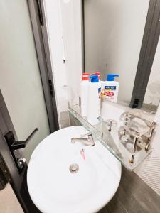 a bathroom with a white sink and a mirror at 202 부이비엔 도보 10분 , 아늑한 주택 in Ho Chi Minh City +2 photos