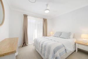Un dormitorio blanco con una cama y una ventana. en Fiesta on Lawson - Belle Escapes Byron Bay, en Byron Bay