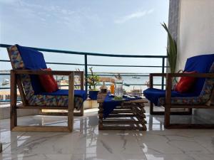 two chairs and a table on a balcony with the ocean at Hotel Cap du Sine Saloum in Ndangane