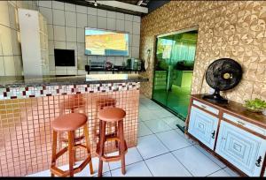 a kitchen with two stools and a counter with a mirror at Residencial Celedone in Boa Vista