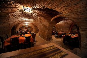 a restaurant with tables and chairs in a stone building at Castel Haller in Ogra