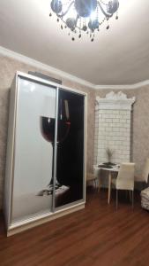 un salon avec une fenêtre en verre avec une bouteille de vin à l'intérieur dans l'établissement Квартира с балконом в центре города, à Odessa