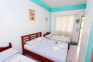 two beds in a room with blue and white walls at Palm Grove Saud Holiday Complex Hotel in Burayoc