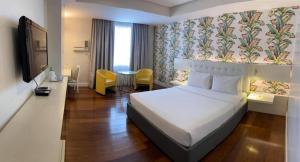 a hotel room with a bed and a tv and a table at DIVERSION 21 HOTEL in Molo +20 photos