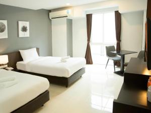 a hotel room with two beds and a desk at B2 Hat Yai Rat Uthit Boutique & Budget Hotel in Sathani Hat Yai +63 photos