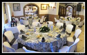 un grupo de mesas con sillas blancas y buscador de mesa en Hotel Enrique Calvillo en El Bosque