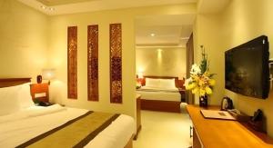 a hotel room with a bed and a desk with a tv at Au Lac 2 Hotel in Ho Chi Minh City