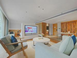 a living room with a couch and a tv at Dongguan Castfast Hotel in Qinglinjing