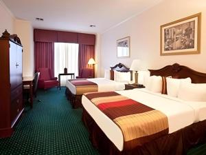 a hotel room with two beds and a desk at Magnuson Grand Conference Hotel in Cypress Gardens