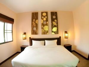 a bedroom with a large white bed with two tables at Monn Phu Phrai in Chiang Mai +115 photos