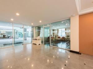 a large room with glass doors and a living room at Romance Hotel Srinakarin in Bangkok