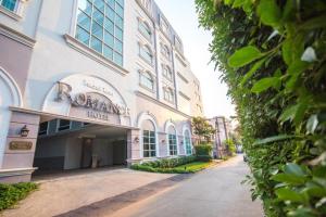 a building with a sign on the side of it at Romance Hotel Srinakarin in Bangkok