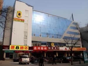 ein großes Gebäude, vor dem Autos parken in der Unterkunft Super 8 Hotel Jinan Railway Station Square in Jinan