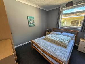 een kleine slaapkamer met een bed en een raam bij Homely Chalet On A Brilliant Holiday Park In Lowestoft Ref 12004B in Lowestoft +10 foto's
