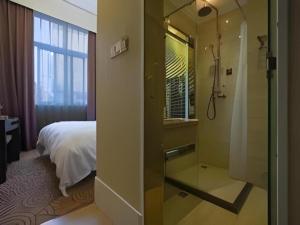 Cette chambre comprend un lit et une salle de bains pourvue d'une douche. dans l'établissement Biway Fashion Hotel - Puyang Huanghe Road, à Zhongyuanyoutian