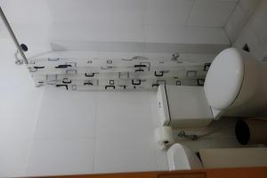 a white bathroom with a toilet and a wall withletters at Hotel Monde in Dagupan +48 photos