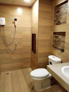 a bathroom with a toilet and a sink at The Vintage Residence in Ban Thung Sukla