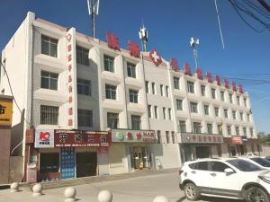 a white car parked in front of a building at GreenTree Inn Zhangye Ganzhou Train Station Orthopaedic Hospital in Zhangye +6 photos