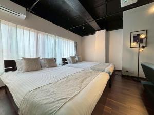سرير أو أسرّة في غرفة في Neighbor's Hotel 西広島駅前