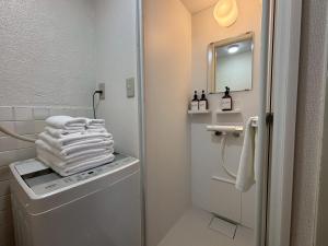 Neighbor's Hotel 西広島駅前 في هيروشيما: حمام به كومه من المناشف على غساله +37 صورة