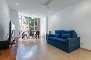 a living room with a blue couch and a table at Espaçoso - Charme House - Copacabana in Rio de Janeiro