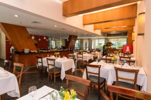 a dining room with white tables and chairs at Transamerica Executive Perdizes in São Paulo