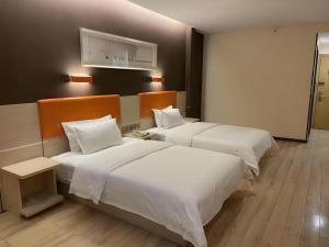 deux lits dans une chambre d'hôtel avec des draps blancs dans l'établissement 7 Days Premium Jinan Gaoxin Qu Wanda Plaza, à Jinan 248 autres photos