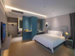 Postel nebo postele na pokoji v ubytování Magnotel Hotel Shiyan Wuyan Pedestrian Street