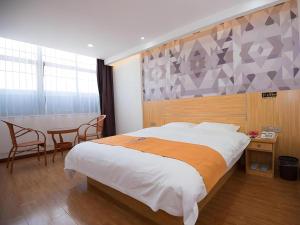 a bedroom with a bed and a table and chairs at PAI Hotel·Xuzhou Pei Country, Yangtun Economic and Technological Development Zone Shiliu K in Datun