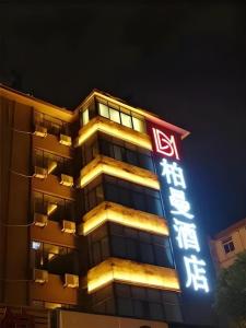 ein Gebäude mit einem Neonschild davor in der Unterkunft Borrman Hotel Hefei Guogou Plaza Sanli'an Metro Station in Hefei