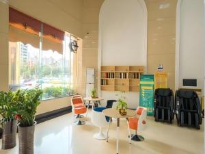 a waiting room with tables and chairs in a building at GreenTree Inn Zhanjiang Haitian Bus Station in Zhanjiang