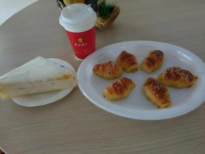 a white plate with five pastries on a table at GreenTree Inn Zhanjiang Haitian Bus Station in Zhanjiang +18 photos
