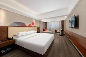 a large white bed in a hotel room at Borrman Hotel Guangzhou Railway Station Sanyuanli Metro Station in Guangzhou