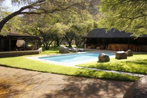 a swimming pool in a yard with a pavilion at Ko Ka Tsara Bush Camp in Beaufort West