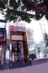 a building with a revolving door in front of it at Echarm Hotel Fuzhou Sanfang Qixiang East Street Metro Station in Fuzhou