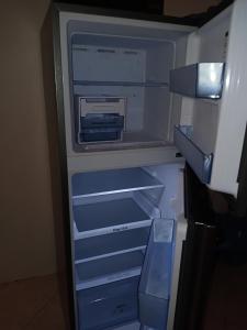 an empty refrigerator with its door open with its door open at Chetty Tourist Residence in Pereybere
