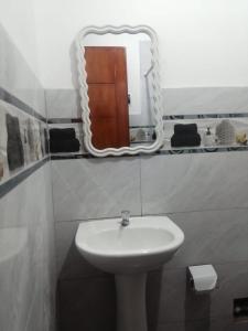 un baño con lavabo y espejo en Alojamiento Miller, en Ayacucho