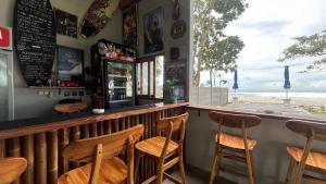 a bar with chairs and a view of the ocean at AK's Surf Resort in Wainapal