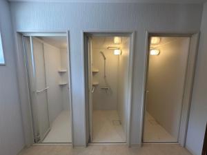 two glass doors in a bathroom with a shower at モンゴリアンテーマパークジャパン in Kamigō