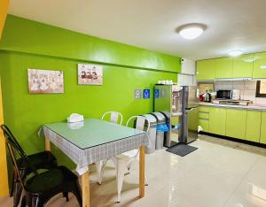 a kitchen with a table and a green wall at 時光旅舍 in Jincheng